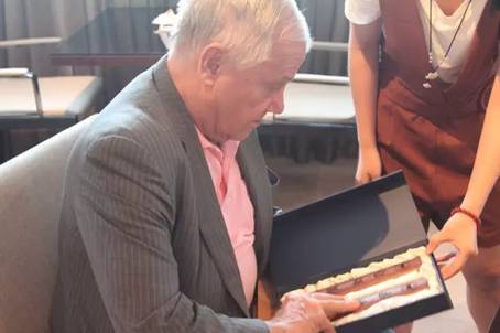 郭乐源向罗杰斯先生赠送建大礼品